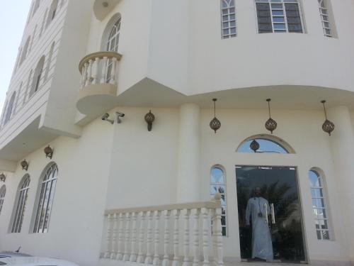a white building with a white dress in the doorway at Al Ferdous Hotel Apartments in Muscat
