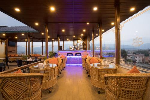 a restaurant with wicker chairs and tables on a balcony at Boudha Boutique Hotel in Kathmandu
