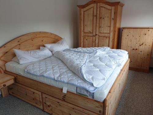 a bedroom with a wooden bed and a wooden cabinet at Apartment im Herzen von Neustrelitz in Neustrelitz