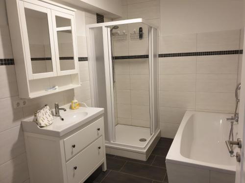 a bathroom with a shower and a sink and a tub at Apartment im Herzen von Neustrelitz in Neustrelitz