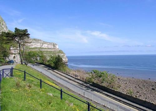 a road next to the ocean on a cliff at The Grand Hotel in Llandudno