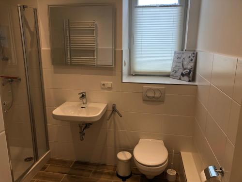 a small bathroom with a toilet and a sink at Haus Rechteck in Grömitz