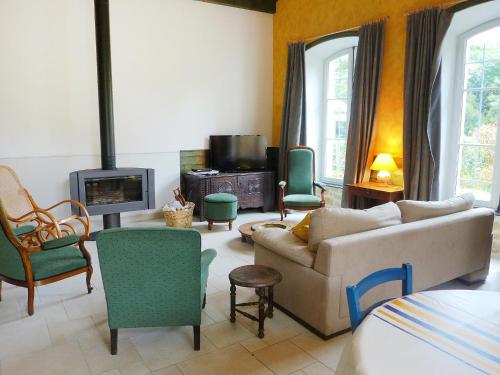 a living room with a couch and chairs and a tv at Holiday Home Le chant des milans by Interhome in Ondres