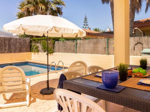 un patio con una mesa con sombrilla y una piscina en Holiday Home 1 Casas by Interhome, en Riumar