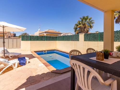 un patio trasero con piscina, mesa y sillas en Holiday Home 2 Casas by Interhome, en Riumar