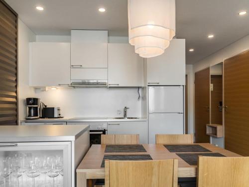 a kitchen with white cabinets and a table and chairs at Holiday Home Nordic chalet 9408 by Interhome in Ylläs