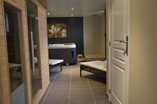 Ένα μπάνιο στο Hôtel-Spa-Piscine Le Petit Castel Beuzeville-Honfleur
