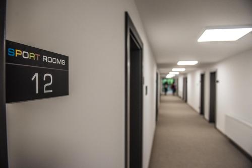 a sign on the wall of an empty hallway at Sport Rooms Spała in Spała