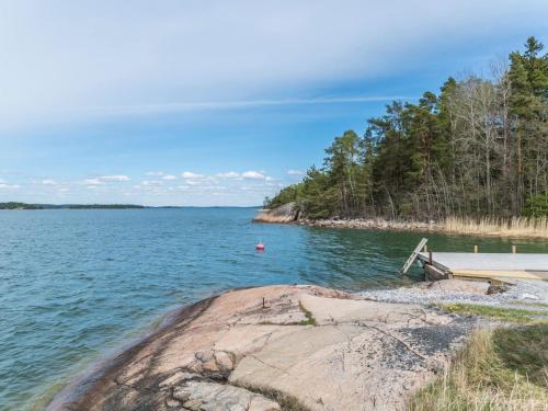 a bench sitting on the shore of a body of water at Holiday Home Villa pääsky by Interhome in Karuna