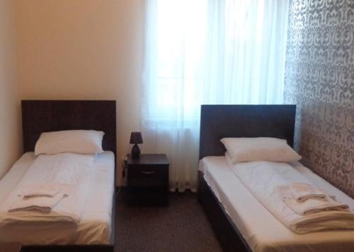 1 dormitorio con 2 camas y ventana en Hotel & Restauracja Euforia, en Garwolin