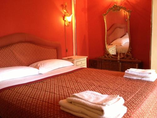 una camera da letto con un letto con specchio e asciugamani di B&B Domus Dei Cocchieri a Palermo