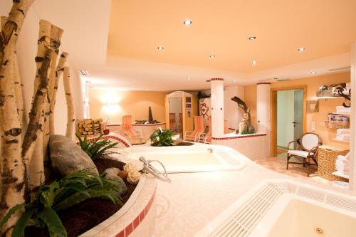 un ampio bagno con vasca e albero di Hotel Garni Hainbacherhof a Sölden