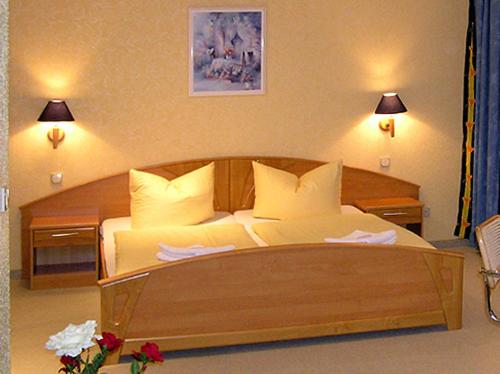 Un dormitorio con una gran cama de madera con almohadas en Waldhotel Seelow en Seelow