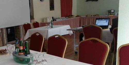 a room with tables and chairs and a laptop computer at Waldhotel Seelow in Seelow
