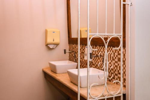 a bathroom with a sink and a mirror at Hotel Villa Rebellato in Olímpia