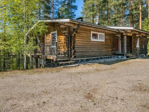 a log cabin in the woods with a porch at Holiday Home Patu by Interhome in Pihlajaniemi