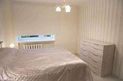 een slaapkamer met een bed, een dressoir en een raam bij Vintage style apartment 1 km from the beach in Pärnu