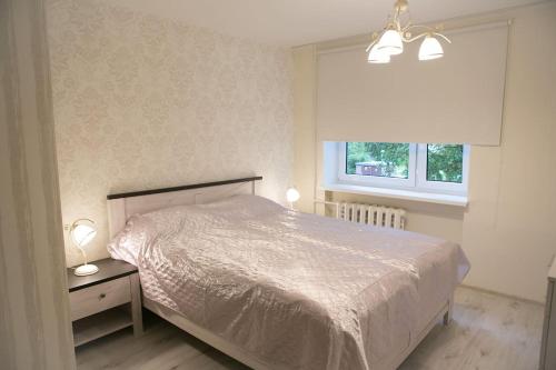 een slaapkamer met een bed en een raam bij Vintage style apartment 1 km from the beach in Pärnu