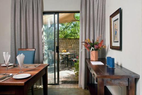 a dining room with a table and a view of a patio at Ama Casa Cottages in Champagne Valley