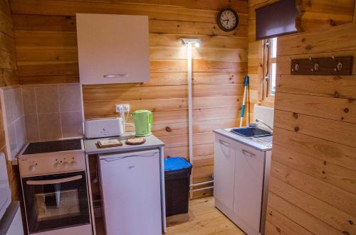 a small kitchen with a stove and a refrigerator at Le Chalet De Louyère in Saint-Salvadour