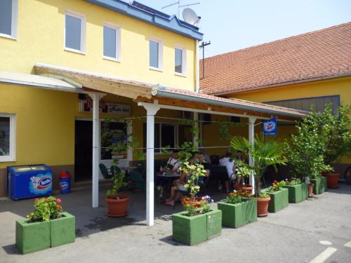 a restaurant with plants and people sitting at a table at Moto klub Brod in Slavonski Brod