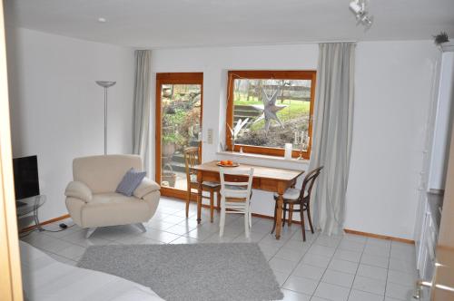 a living room with a table and a chair at Ferienwohnung Fischer in Frickingen