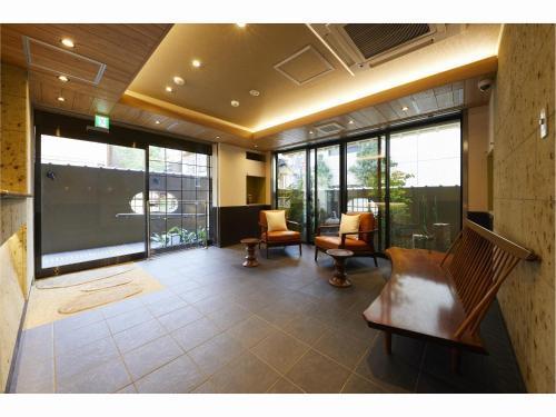 a living room with chairs and a large window at Rinn Miyagawacho Grande in Kyoto