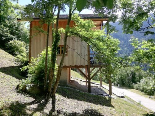 una casa en un árbol con balcón en medio de árboles en La cabane du pommier, en Orelle