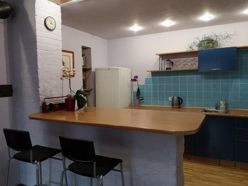 una cucina con un bancone con sedie e un frigorifero di Park apartment a Kaunas