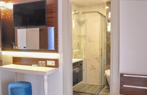 a bathroom with a shower and a sink and a toilet at Cleopatra Golden Beach Hotel in Alanya
