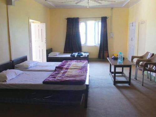 1 dormitorio con 2 camas, mesa y sidx sidx sidx de mesa en Chikar Highland Resort en Muzaffarābād