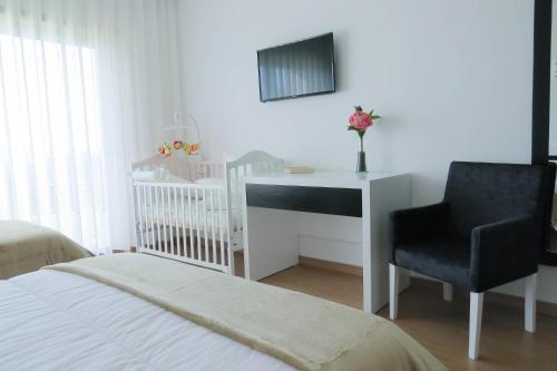 a bedroom with a desk and a chair and a crib at Casa Miradouro in Mesão Frio