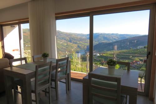 a dining room with a table and chairs and a large window at Casa Miradouro in Mesão Frio