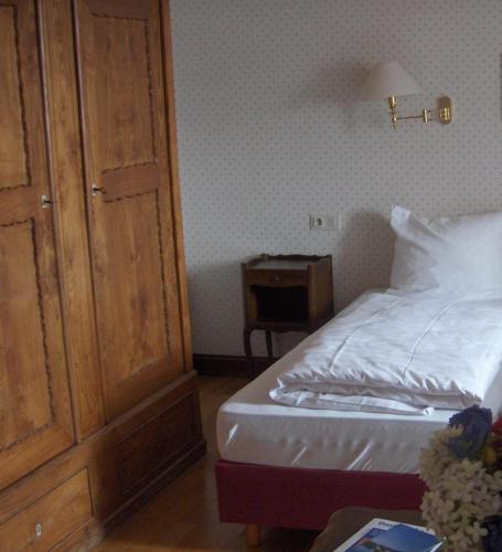 a bedroom with a bed and a wooden cabinet at Hotel zum alten Brauhaus in Dudeldorf