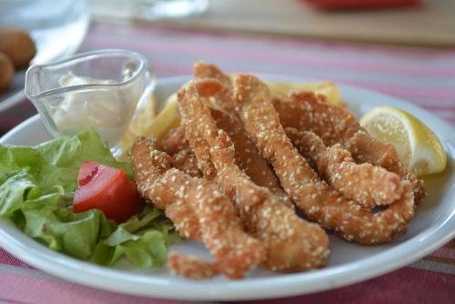a plate of food with chicken tenders and a salad at Flamingo Resort in Belgrade