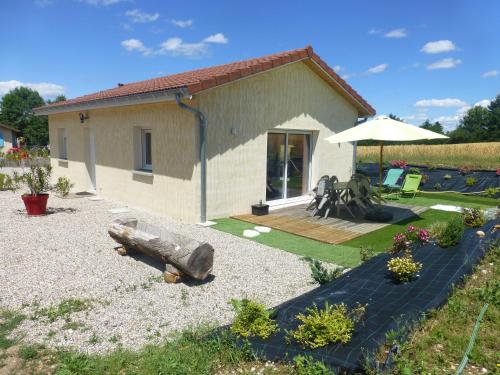 una pequeña casa con un patio trasero con un tronco en Le Messimy, en Charnoz