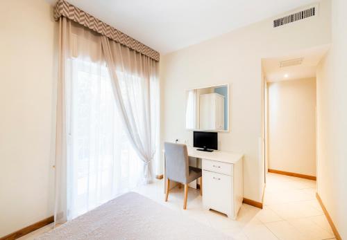 a bedroom with a white bed and white walls at Hotel Andreaneri in Marina di Pietrasanta