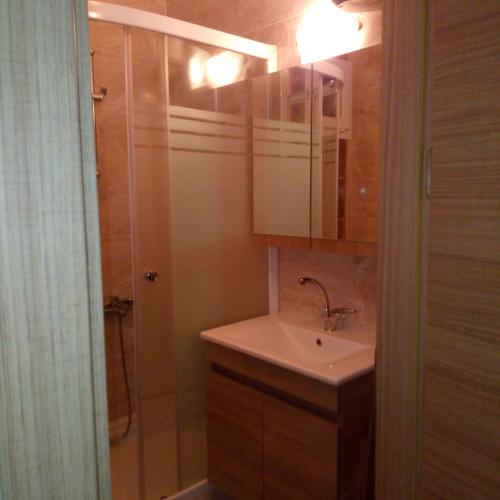 a bathroom with a sink and a mirror and a shower at GÜMÜLDÜR ÇALIŞKAN APART 1 in Gumuldur