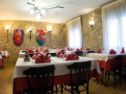 a dining room with tables with red napkins on them at Fonda Bohemia Riuot in Montblanc