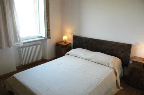 1 dormitorio con 1 cama blanca y ventana en Casa Mimmo, en Castiglione in Teverina