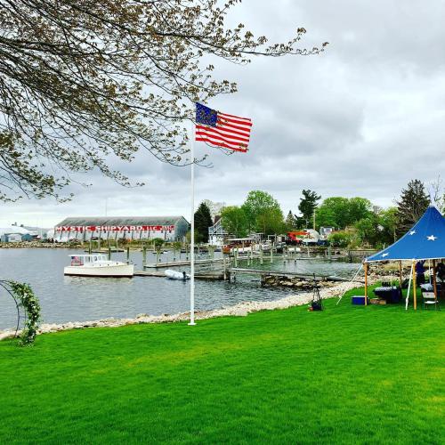 an american flag flying in the grass next to a marina at Harbor View Landing in Mystic