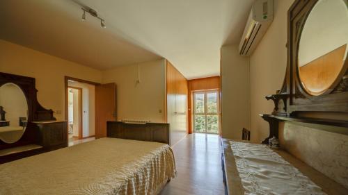 - une chambre avec un lit et un grand miroir dans l'établissement Casa Panorâmica Aurora, à Castelbuono