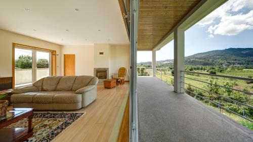 een woonkamer met een bank en een groot raam bij Casa Panorâmica Aurora in Celorico de Basto