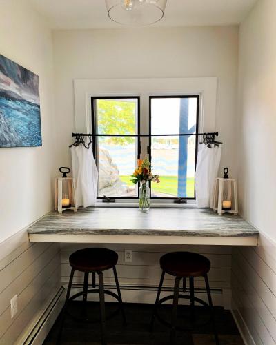 a counter in a room with two stools and a window at Harbor View Landing in Mystic