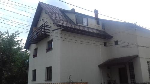 a white house with a black roof at Pensiunea Simona in Bran