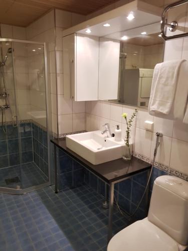 a bathroom with a sink and a shower and a toilet at 2ndhomes Deluxe Kamppi Center Apartment with Sauna in Helsinki