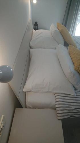 a white bed with pillows and a lamp in a room at Apartments Nina in Rab