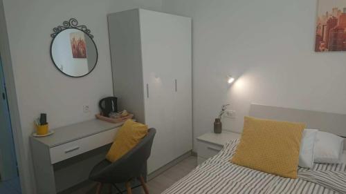a bedroom with a bed and a desk and a mirror at Apartments Nina in Rab