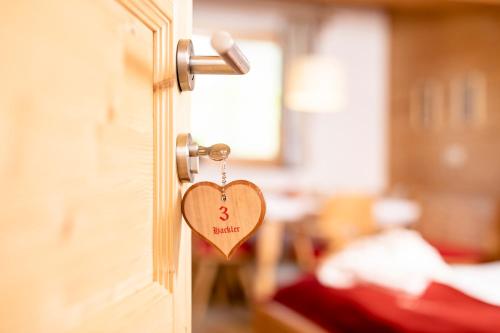 a heart shaped door tag hanging from a bedroom door at Bergwald Appartements Alpbach in Alpbach