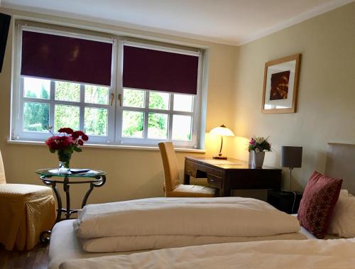 a hotel room with two beds and a desk and window at HEINRICHs winery bed & breakfast in Langenlonsheim